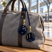 Safety Dice an einer grauen Weekender-Tasche